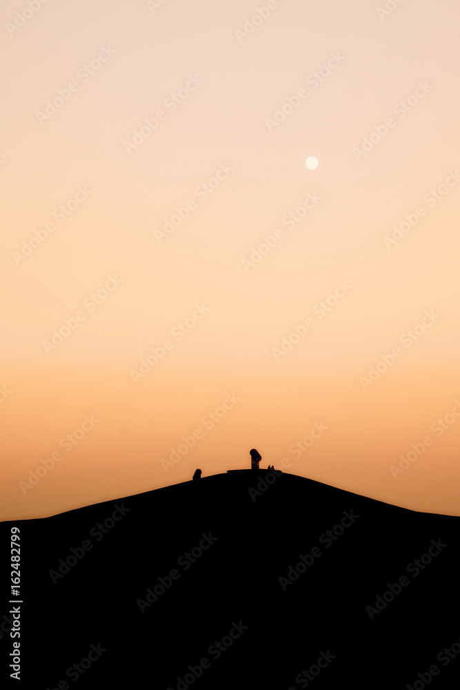 Fototapeta Halde in Gelsenkirchen mit zwei Menschen auf dem Gipfel während Sonnenuntergang