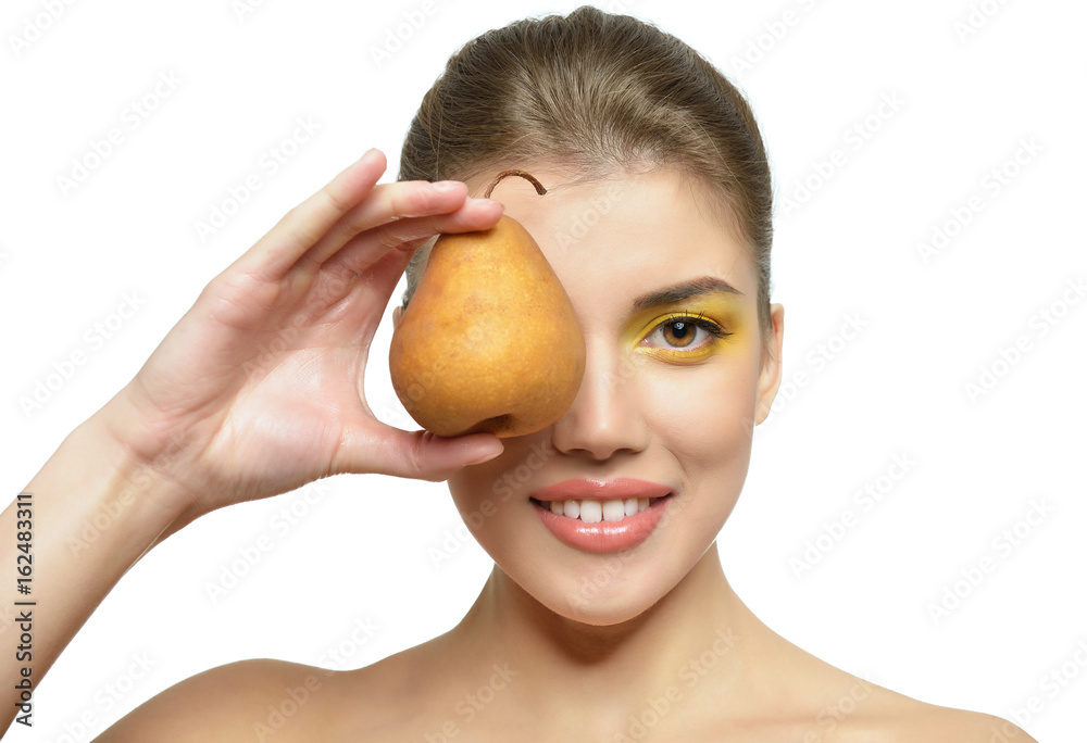 Young attractive girl posing at studio with ripe pear. Beautiful female face with healthy skin and art makeup. Health care, cosmetology, antiaging, beauty treatment, diet, feminity, spa concept. Young attractive girl posing at studio with ripe pear. Beautiful female face with healthy skin and art makeup. Health care, cosmetology, antiaging, beauty treatment, diet, feminity, spa concept.
