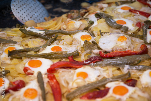 Street food in San Fermin feast, Pamlona, Navarra, Spain. Fried eggs. Scrambled eggs with vegetables. Spanish traditional cuisine. Spanish national dish. photo