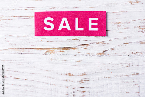 Sale sign on wooden background