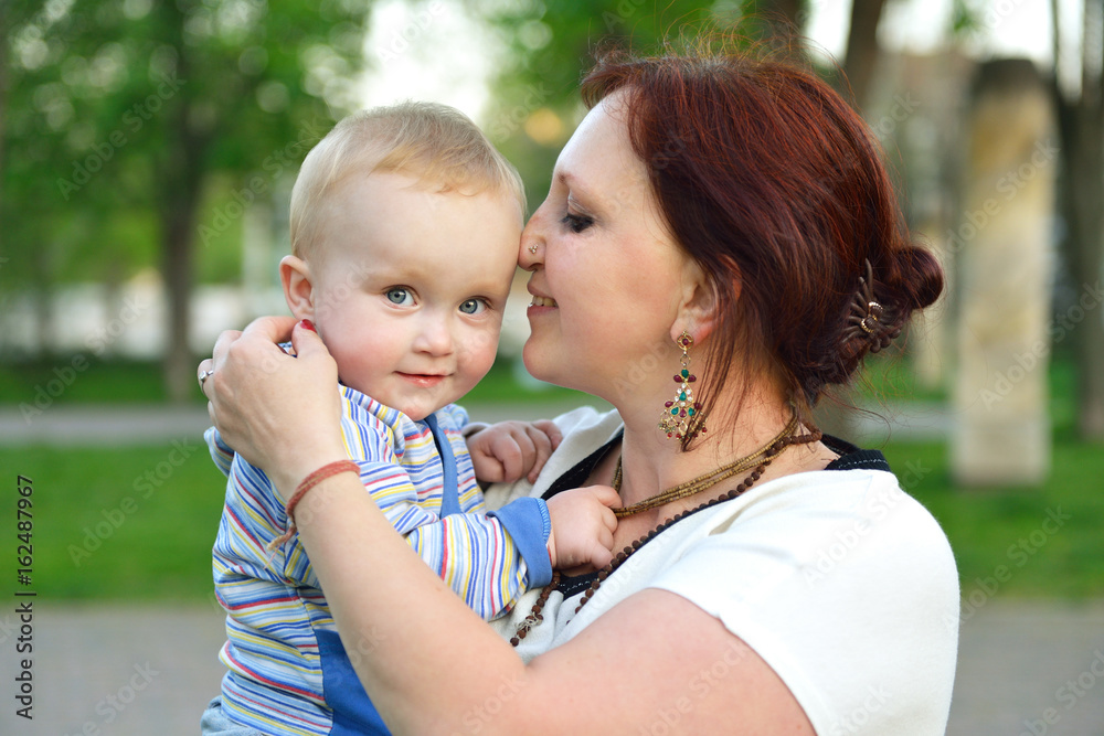 Happy mother holding her adorable little son. Family outdoor leisure. Little kid with his mom playing in park. Happy mother holding her adorable little son. Family outdoor leisure. Little kid with his mom playing in park.