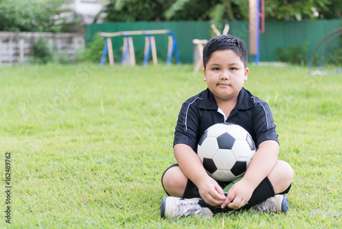 sitting obese fat boy  soccer player with football © kwanchaichaiudom