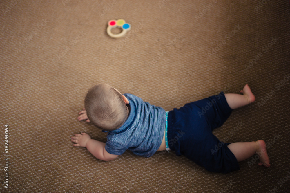 Naklejka premium Little baby playing on living room floor