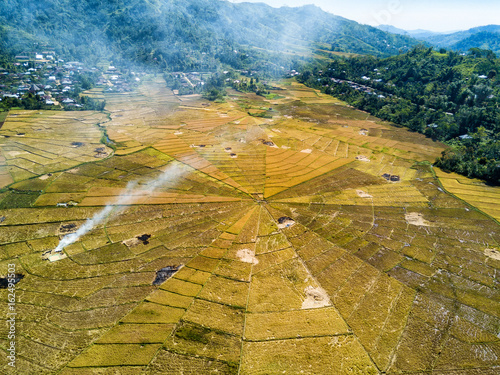 Aerial view of the harvest and burning of rice fields at the famous spider rice fields near Ruteng, Indonesia. photo
