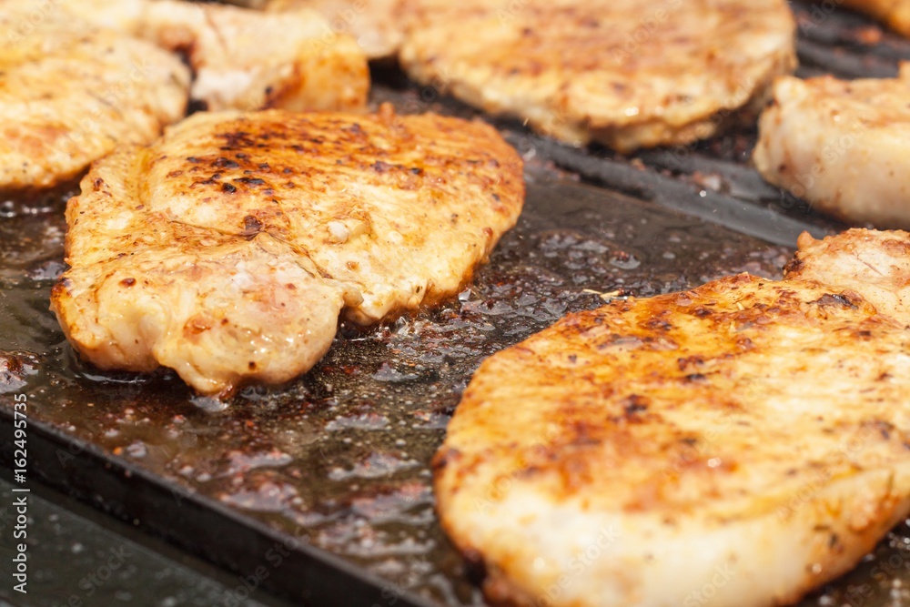 Chicken and pork on electric grill. Summer barbecue. Close-up view.