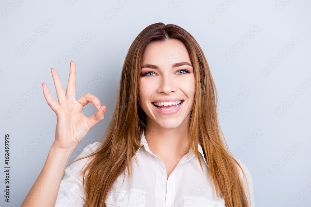 Well done! Young attractive entrepreneur is very excited and showing ok sign, wearing smart outfit, standing on pure background Well done! Young attractive entrepreneur is very excited and showing ok sign, wearing smart outfit, standing on pure background
