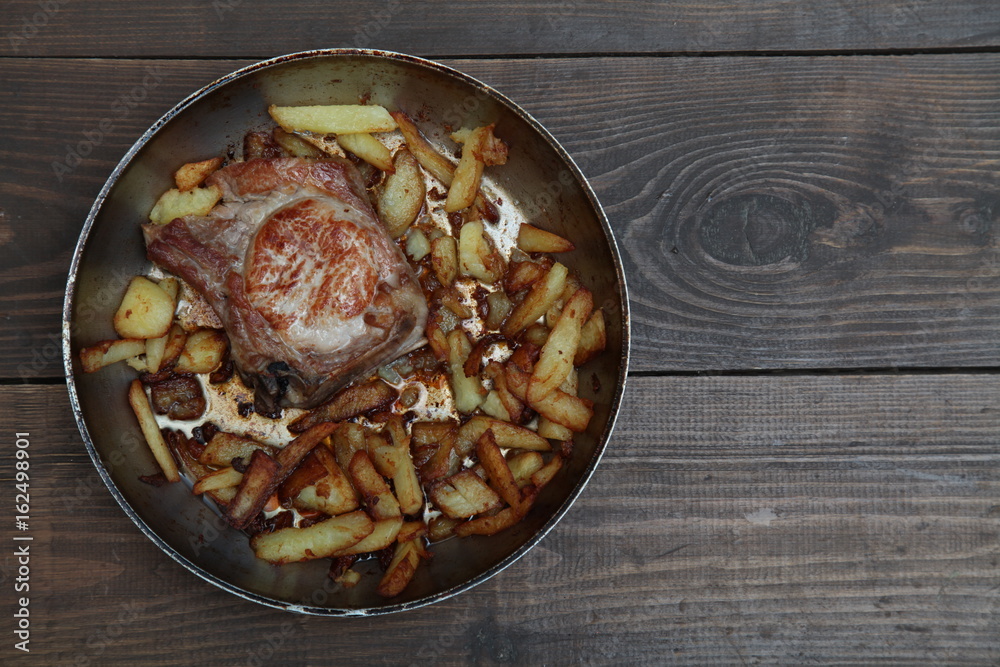 dinner with pan fried meat and potatoes on a table dinner with pan fried meat and potatoes on a table