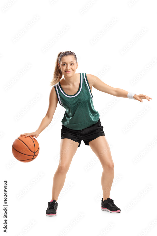 Full length portrait of a young woman playing basketball