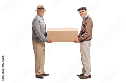 Canvas Print Two mature men holding a big cardboard box