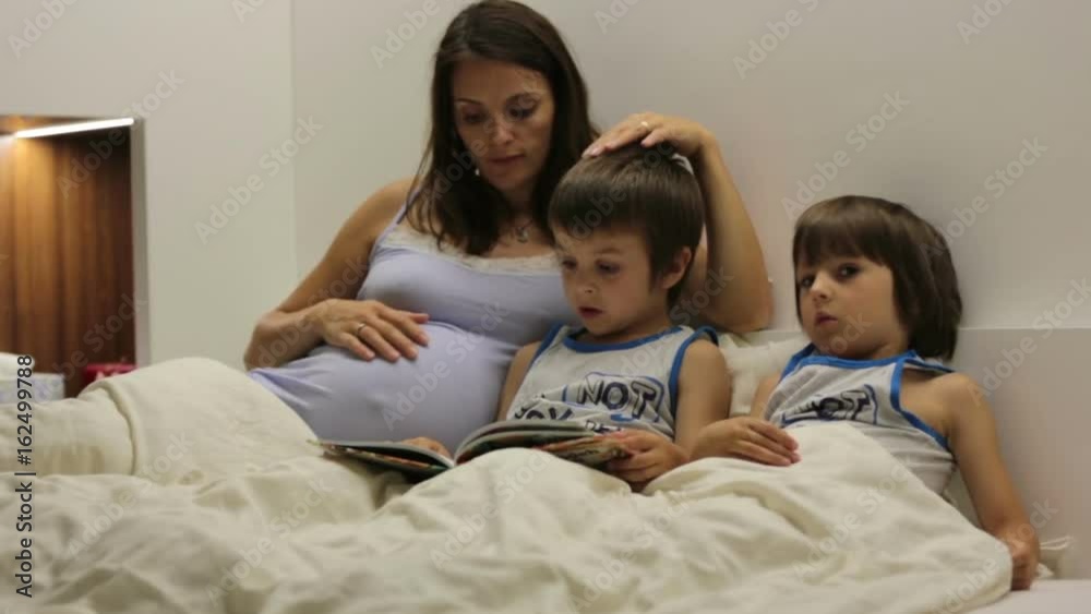 Pregnant mum, reading bedtime story for her sons Pregnant mum, reading bedtime story for her sons