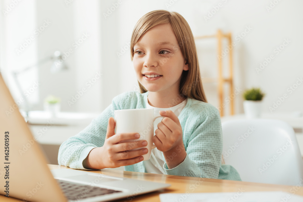 Beautiful committed girl enjoying some warm tea