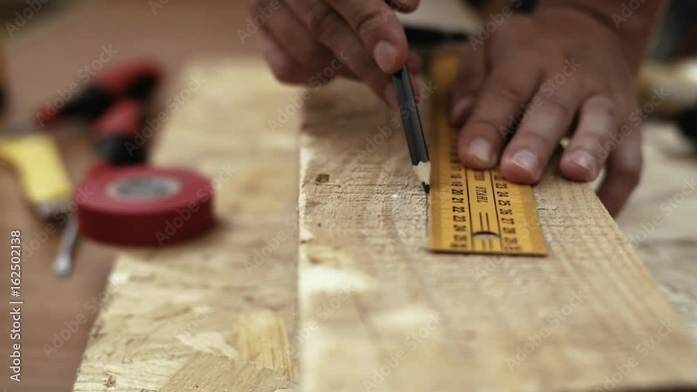 Woodworker drawing mark on timber in the workshop. Carpentry concept. Woodworker drawing mark on timber in the workshop. Carpentry concept.