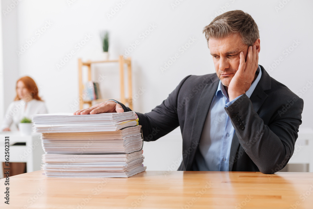 Exhausted sad employee overwhelmed by the workload Exhausted sad employee overwhelmed by the workload