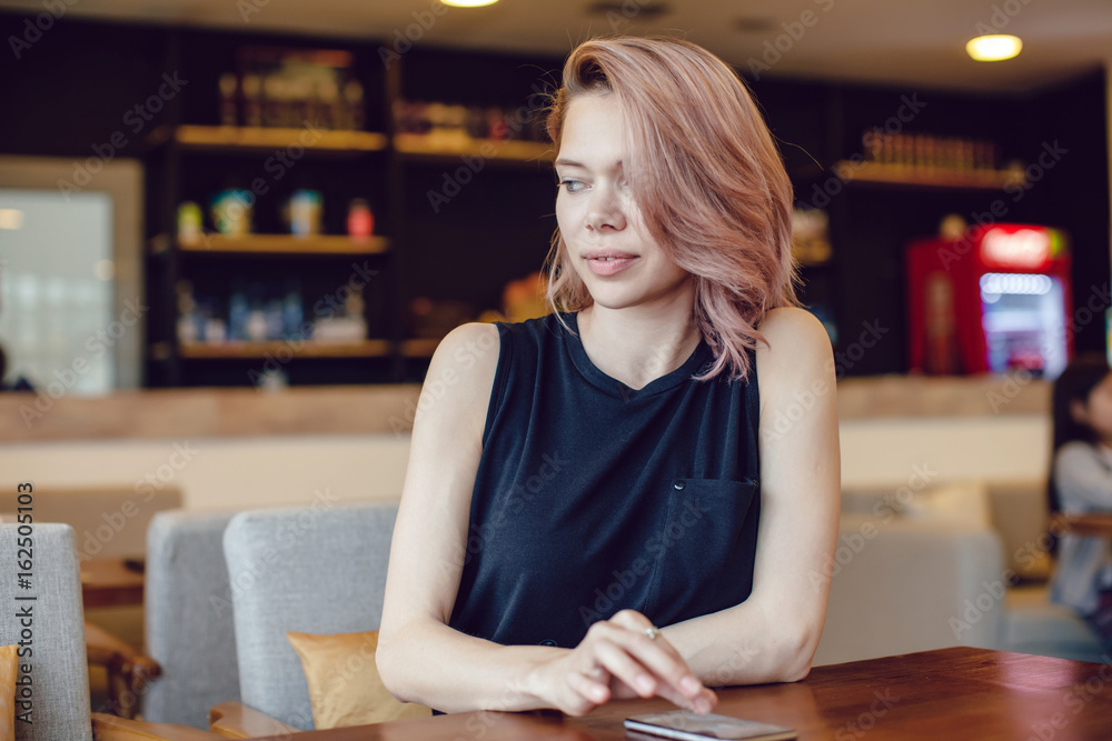 Attractive woman sitting at the cafe and using smartphone. Attractive woman sitting at the cafe and using smartphone.