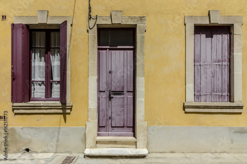 Yellow french house with red shutters at french small town southern France © ksu_bu