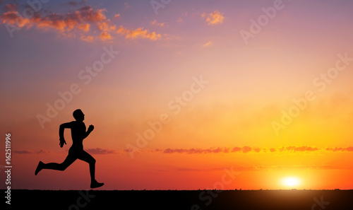 Running man silhouette in sunset time. Sport and active life concept photo