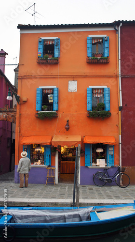 A man looks at a house on the island of Burano near Venice