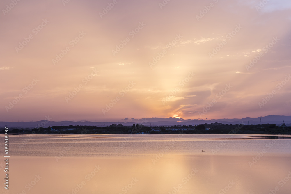 Pink orange and purple Carnon-Plage Montpellier sunset above water southern France