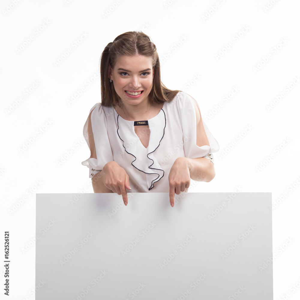 Young playful woman portrait of a confident businesswoman showing presentation, pointing placard gray background. Ideal for banners, registration forms, presentation, landings, presenting concept.. Young playful woman portrait of a confident businesswoman showing presentation, pointing placard gray background. Ideal for banners, registration forms, presentation, landings, presenting concept..
