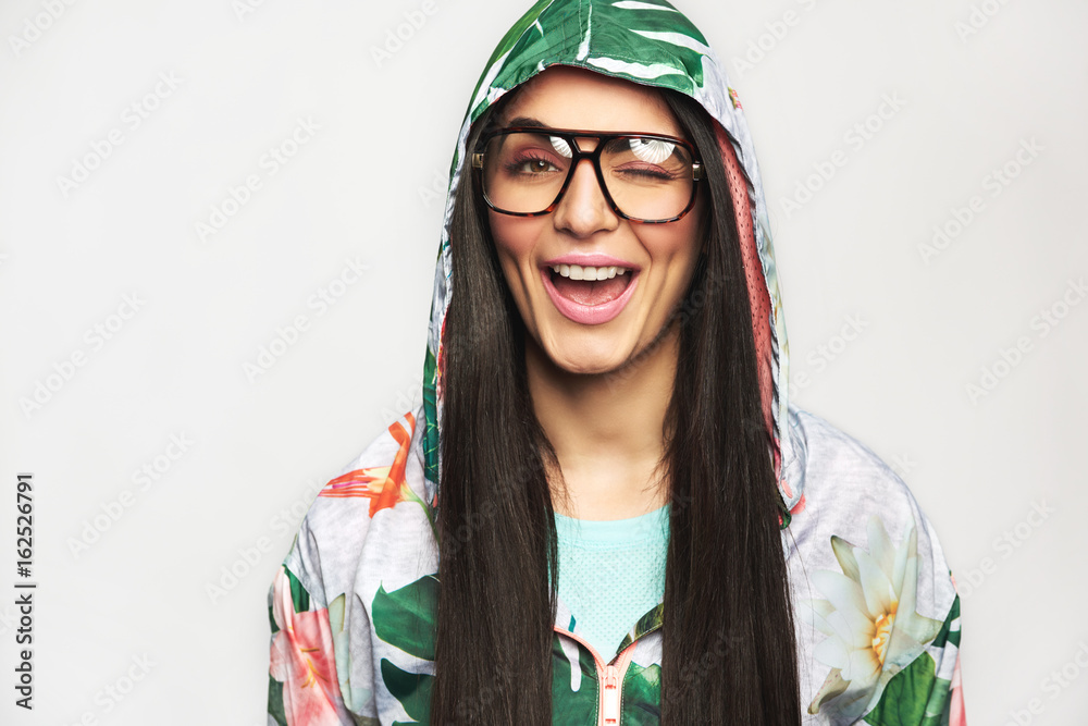 Fototapeta premium Pretty young woman in casual clothes winking at camera