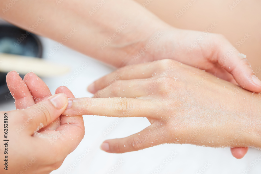Woman Getting a Salt Scrub Beauty Treatment on hands in the Health Spa