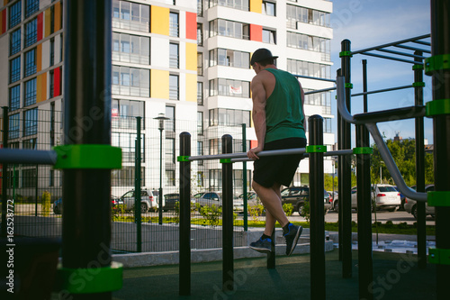 Handsome sexy male bodybuilder athlete man doing crossfit workout in athletic facilities on sunny morning outdoors. Healthy lifestyle concept. Physical preparation of the body