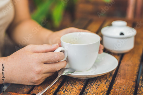 Fototapeta Naklejka Na Ścianę i Meble -  Woman is holding a cup of coffee