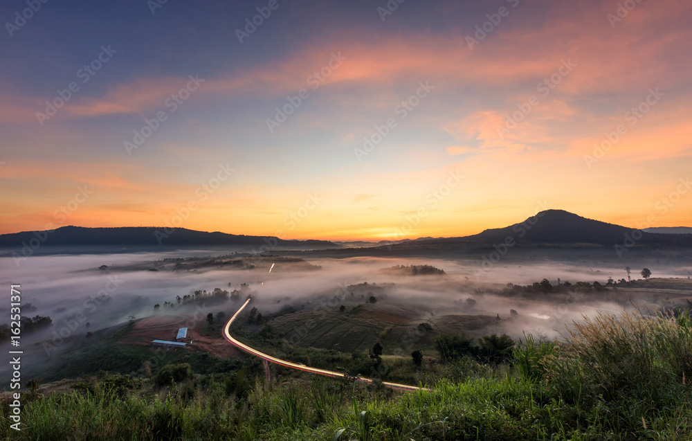 Landscape misty view. Fantastic dreamy sunrise on rocky mountains with view into misty valley below. Foggy clouds above forrest. View below to fairy landscape. Foggy forest hills.