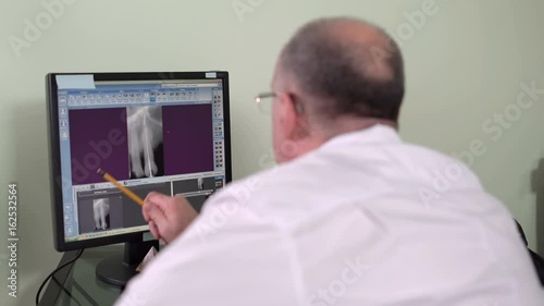 Wallpaper Mural Dentist Sitting at a Computer in the Dental Office Carefully Examines an X-Ray Sealed Root Canal Torontodigital.ca