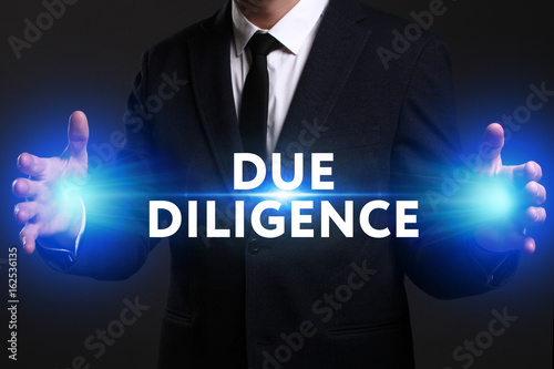 Business, Technology, Internet and network concept. Young businessman working on a virtual screen of the future and sees the inscription: Due diligence