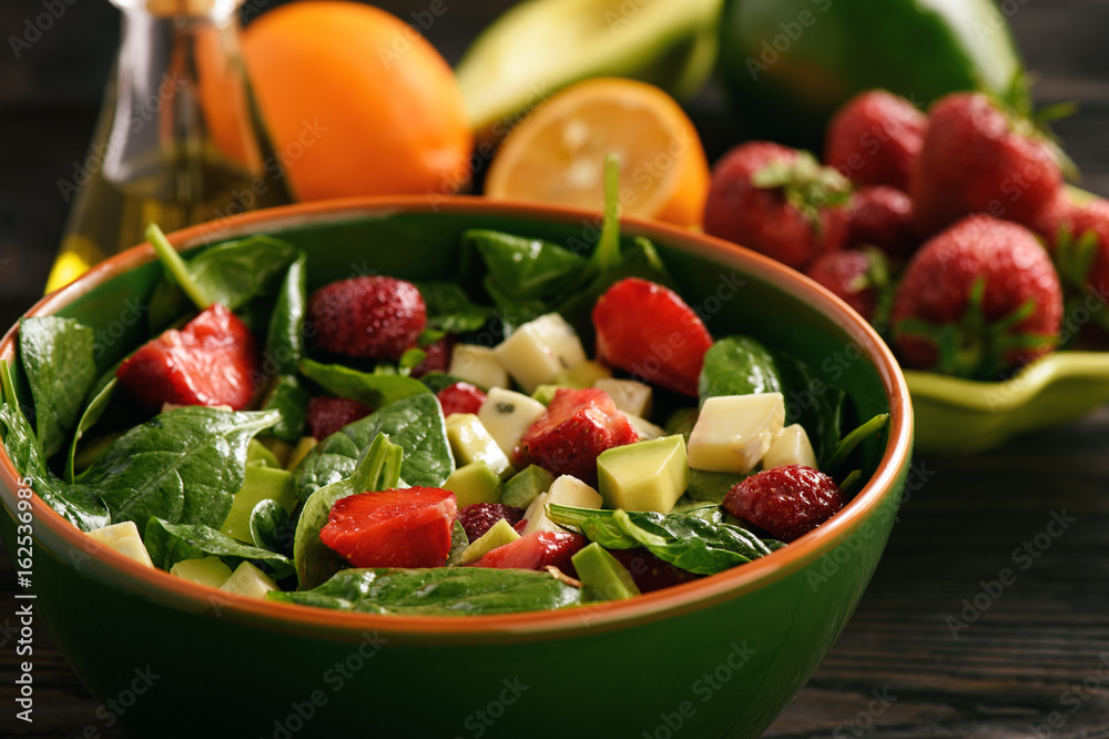 Spinach salad with strawberries, avocado and cheese.