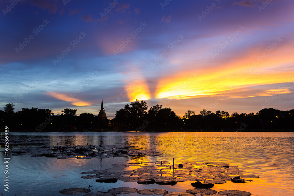 Silhouette Sunset / Sun Rise  Sky and reflection on water at Sukhothai Historical Park of Sukhothai city, Thailand