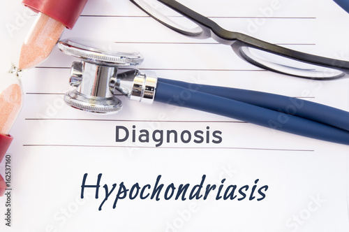 Diagnosis Hypochondriasis. Psychiatric diagnosis Hypochondriasis is written on paper, on which lay stethoscope and hourglass for measuring time to research. Concept photo for psychiatry or psychology photo