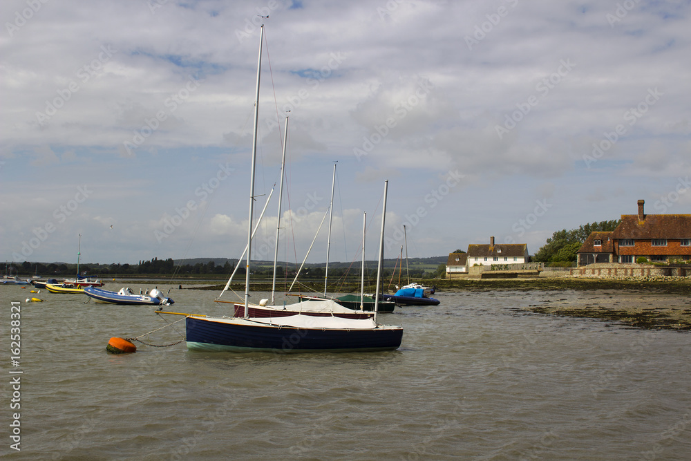 Pleasure boats on their moorings in the  historic Bosham Harbour in West Sussex in the South of England