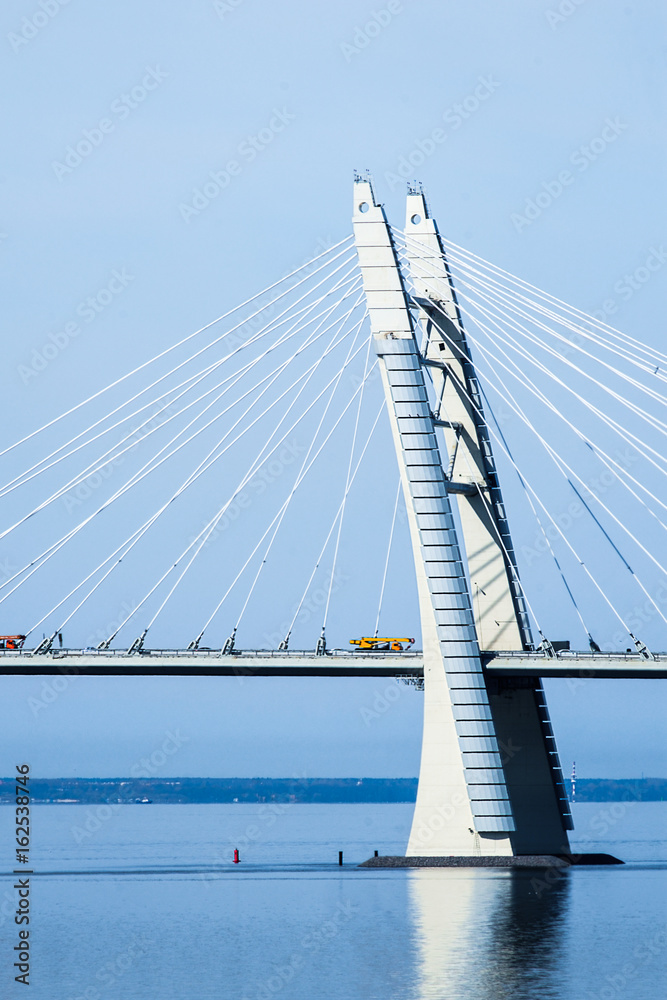 Obraz premium Cable-Stayed Bridge with auto cranes at sunny spring day.