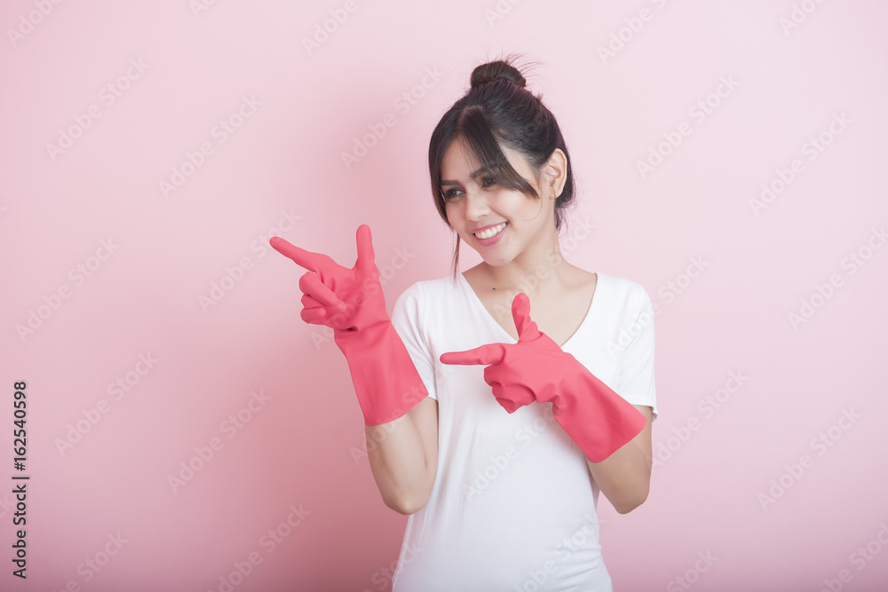 Beautiful asian housewife smiling on pink background Beautiful asian housewife smiling on pink background