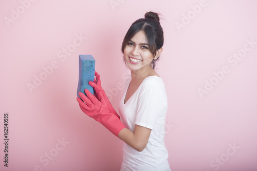 Beautiful asian housewife smiling on pink background