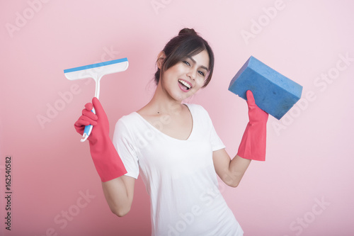 Beautiful asian housewife smiling on pink background