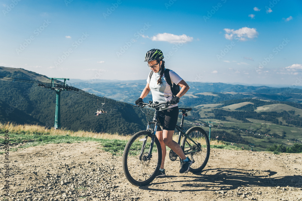 Young woman riding on MTB in mountains