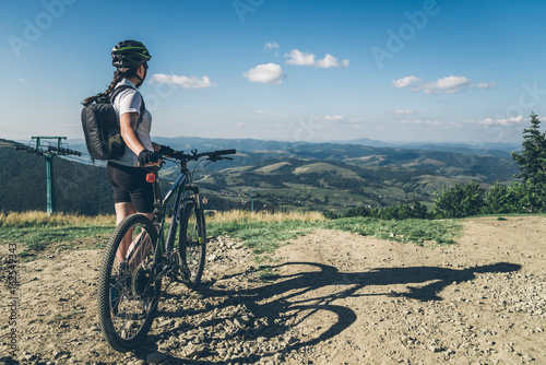 Fototapeta Naklejka Na Ścianę i Meble -  Young woman riding on MTB in mountains