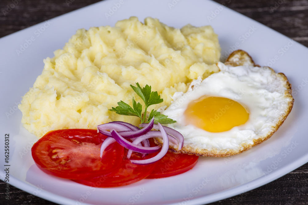 Mashed potatoes with fried eggs and tomato. Mashed potatoes with fried eggs and tomato.