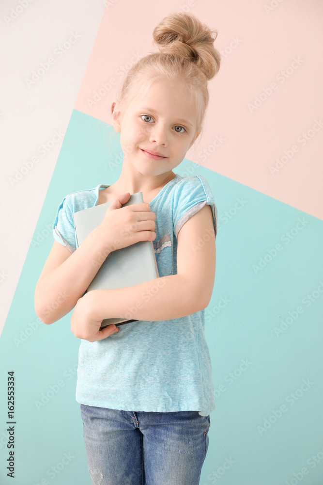 Cute funny girl with book on color background Cute funny girl with book on color background