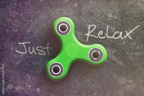 Spinner on the dark background of the word just and relax photo