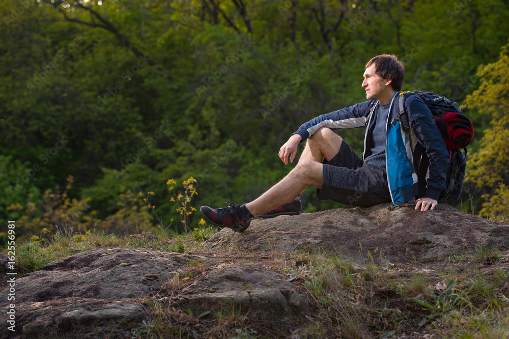 Hiker man takes a rest during summers expedition. Travel, vacation, holidays and adventure concept. Hiker man takes a rest during summers expedition. Travel, vacation, holidays and adventure concept.
