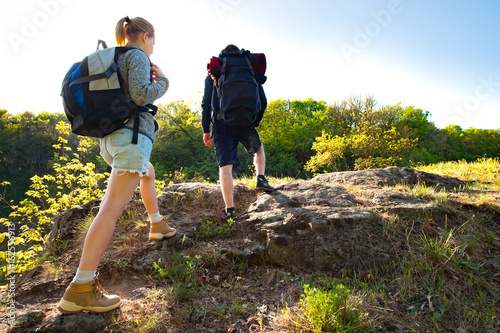Active young Couple hiking in the forest during summer. Travel, hiking, backpacking, tourism and people concept