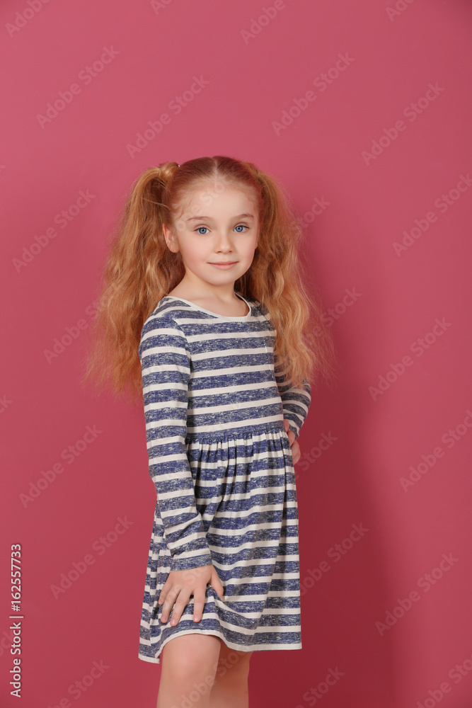 Small girl in striped dress on pink background Small girl in striped dress on pink background