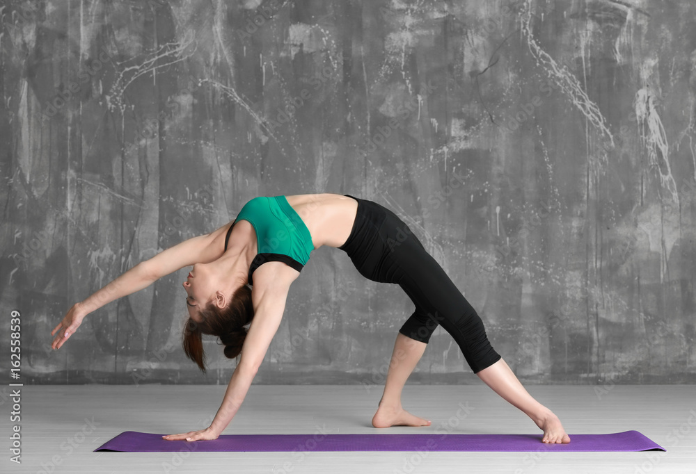 Young woman practicing yoga on grey background Young woman practicing yoga on grey background