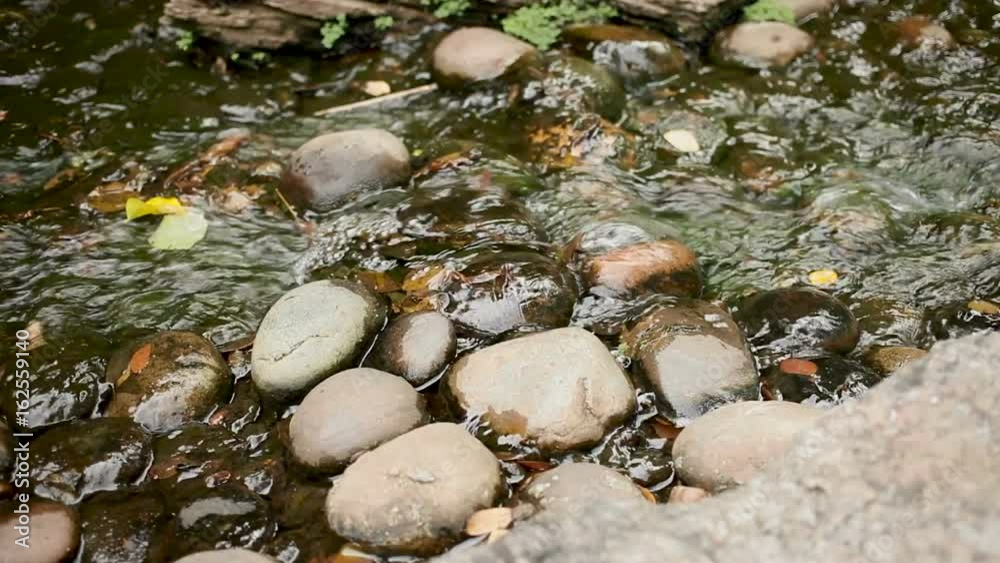 The water of a stream runs over the rocks. Wat Saket (Colden mountain). Bangkok, Thailand.