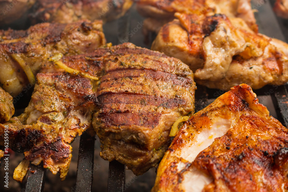 Pork steaks roast on a large grill