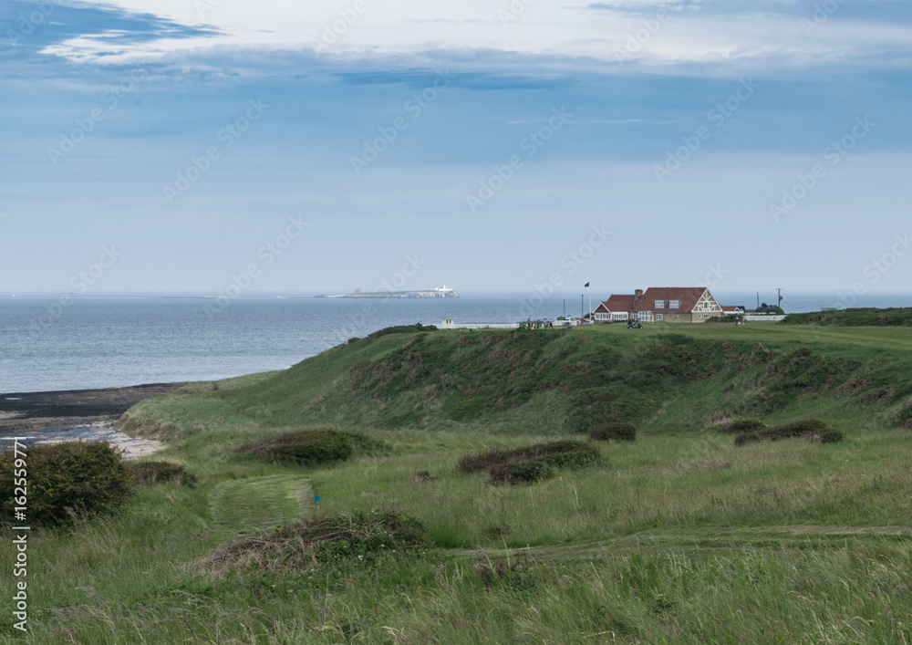 Bamburgh Castle golf club with Farne Islands in the distance